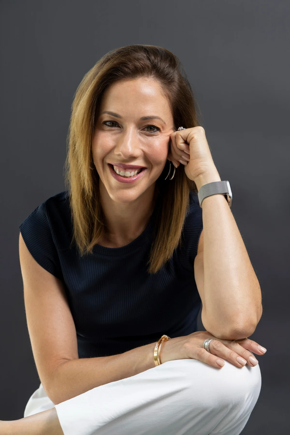 Dr Martine Prunty smiling, with her hand resting against her cheek